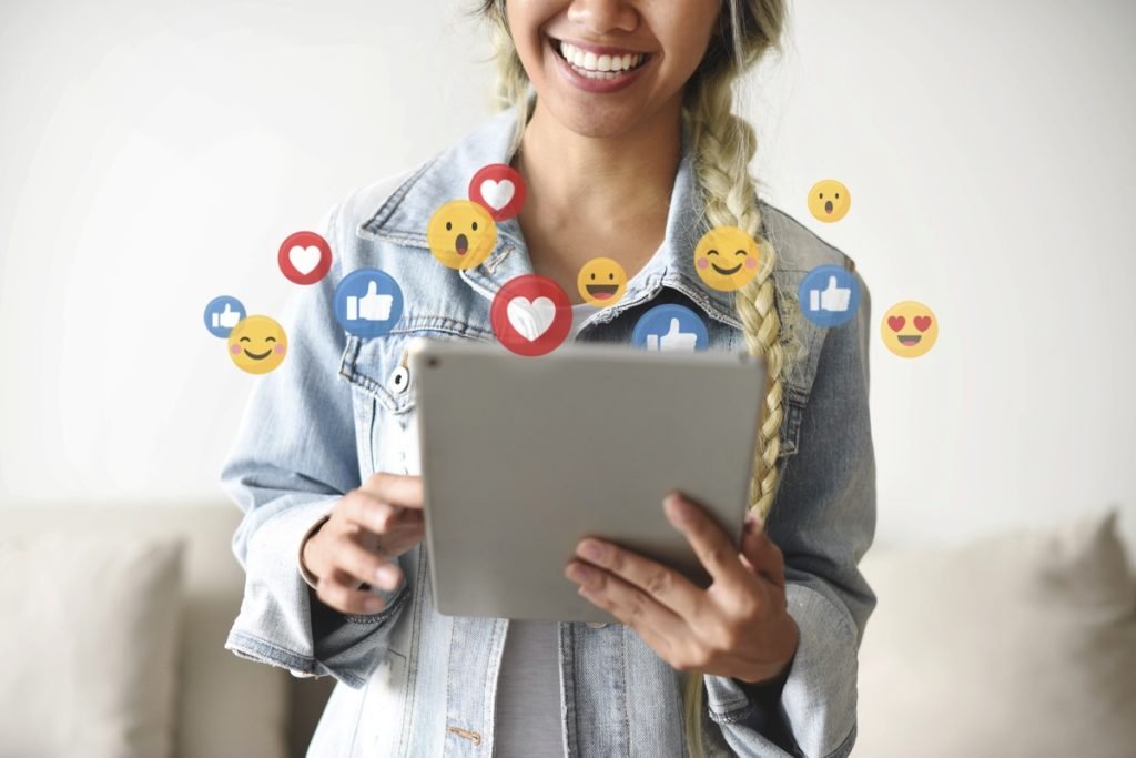 Woman holding a tablet, social icons floating