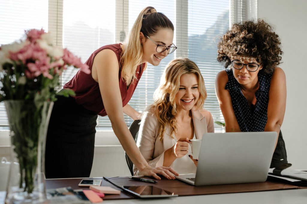 Women leaning over a laptop together