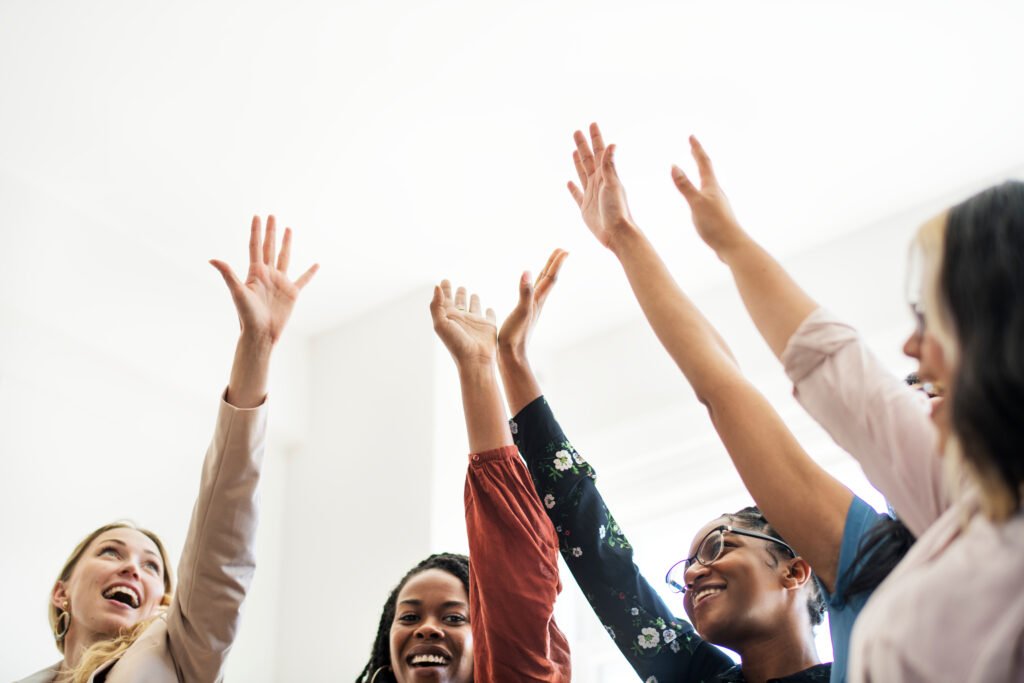 Women raising their hands and celebrating, the feeling when you pay off business debt