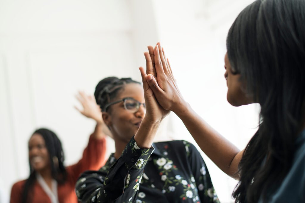 Women high-fiving at a meeting