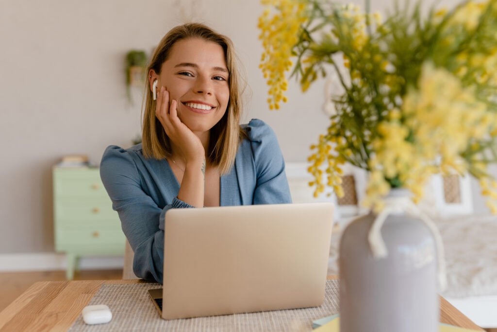 Smiling woman at a laptop with plants