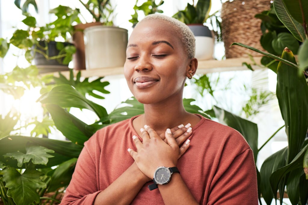 A woman with her hands on her heart, eyes closed, taking a quiet moment to define success for herself