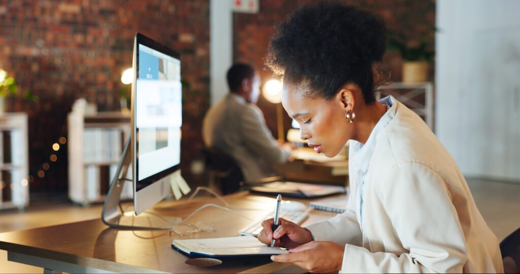Black woman at a computer at night