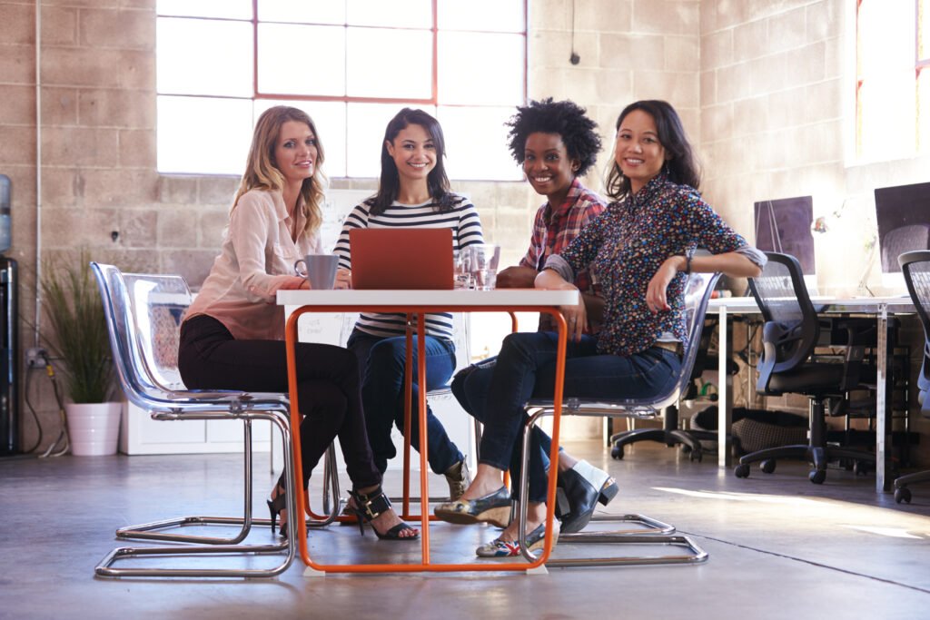 Women meeting at a table in an office, reviewing their numbers for signs the business is in financial trouble.