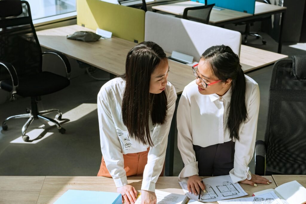 Two women at a table in a modern office, reviewing a contract for red flags.